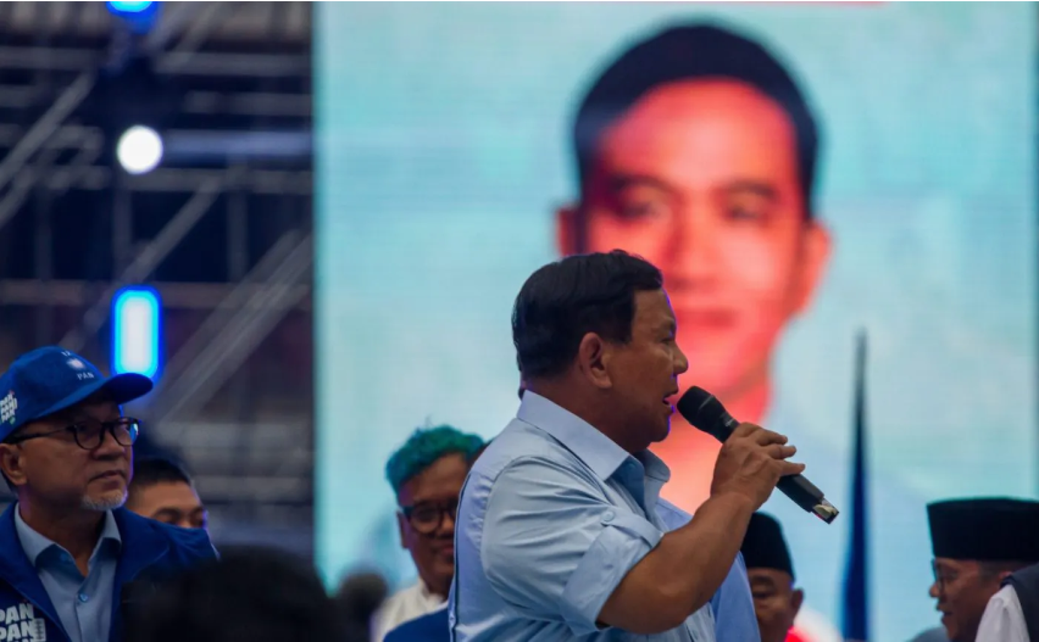 Prabowo Subianto during a campaign rally with Gibran Rakabuming Raka displayed on screen
