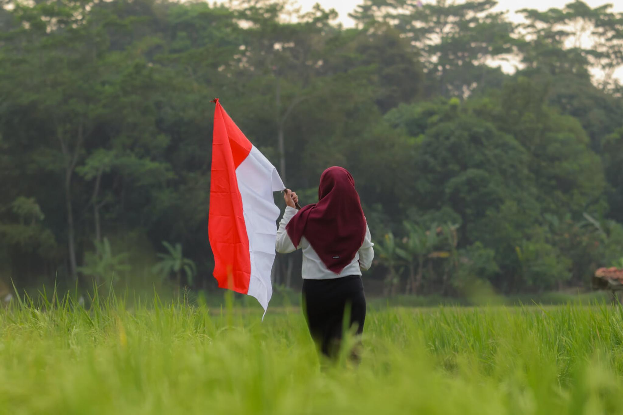 Woman in hijab holding Indonesian flag 