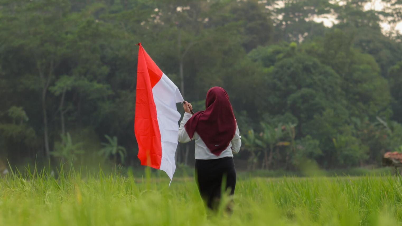 Woman in hijab holding Indonesian flag 